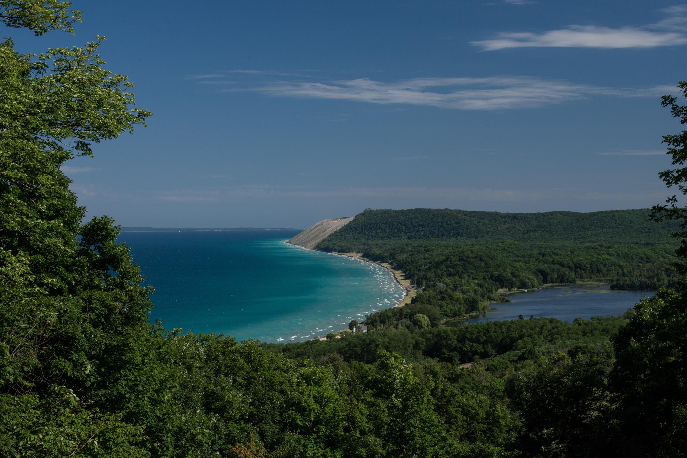 Lake Michigan and the wooded shoreline seen from the Empire Bluffs overlook in Sleeping Bear Dunes National Lakeshore