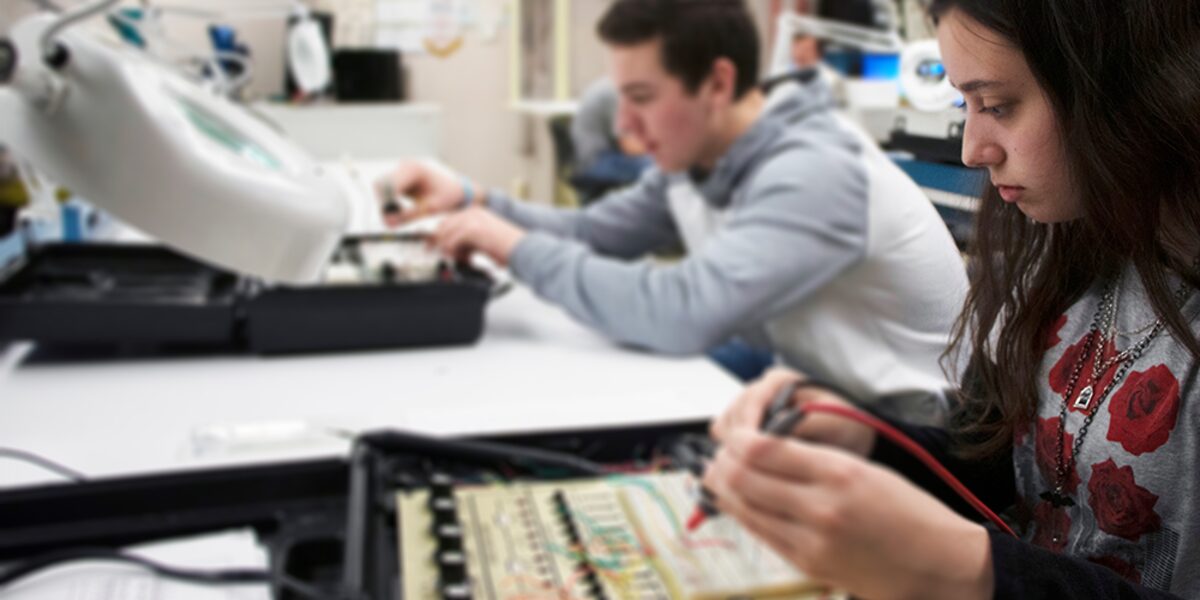 Estudiantes armando un proyecto de robótica en un salón de Bay-Arenac ISD.