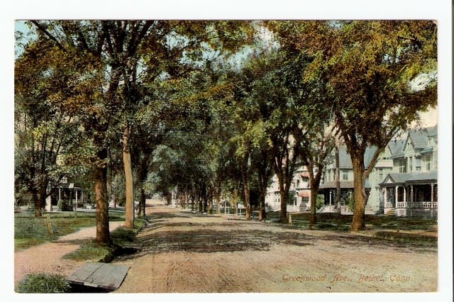 A 1909 postcard looking down Greenwood Avenue, awnings out over the shopfronts
