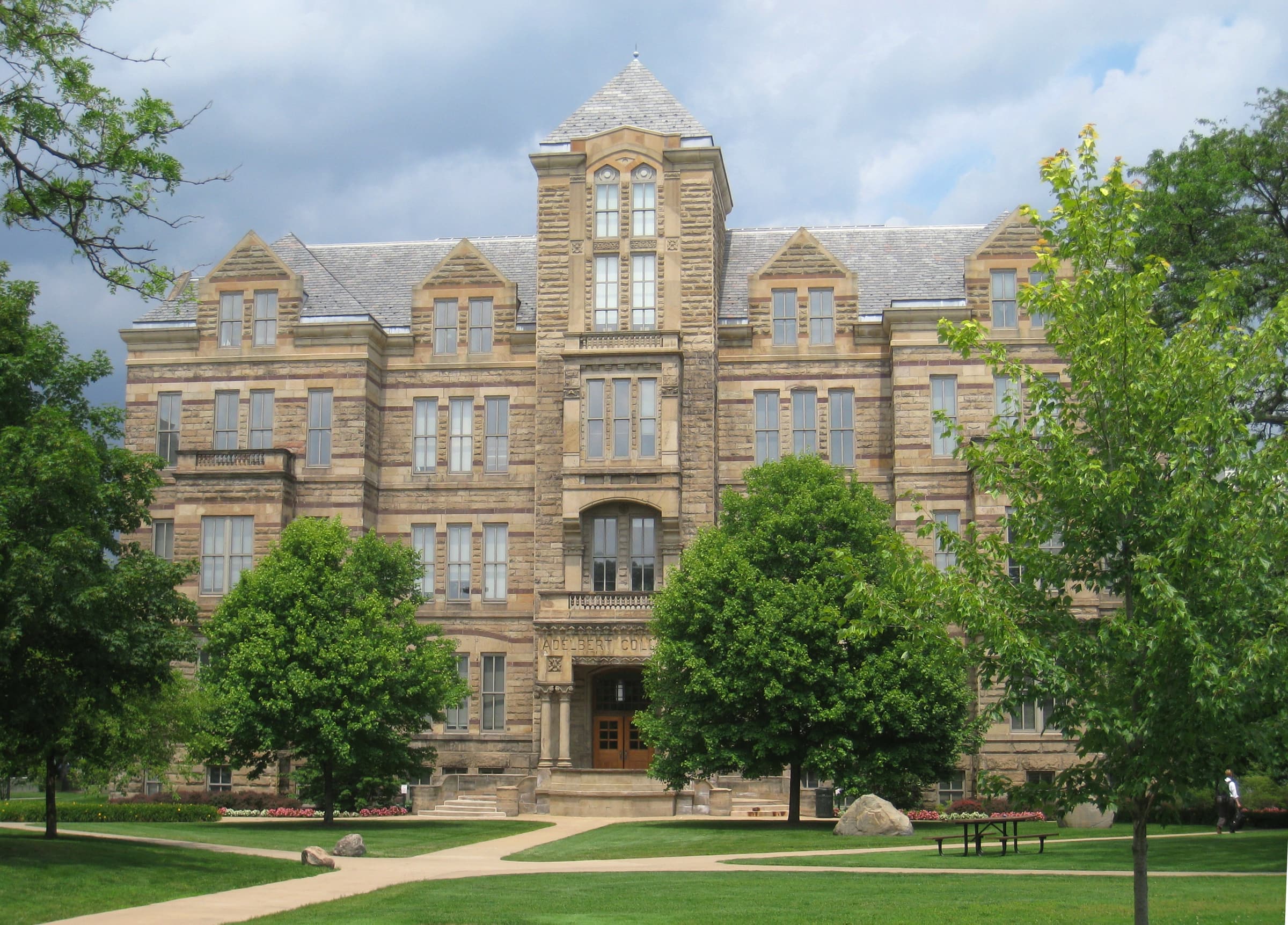 Adelbert Hall, the Romanesque sandstone landmark at Case Western Reserve University, seen across its lawn and trees.