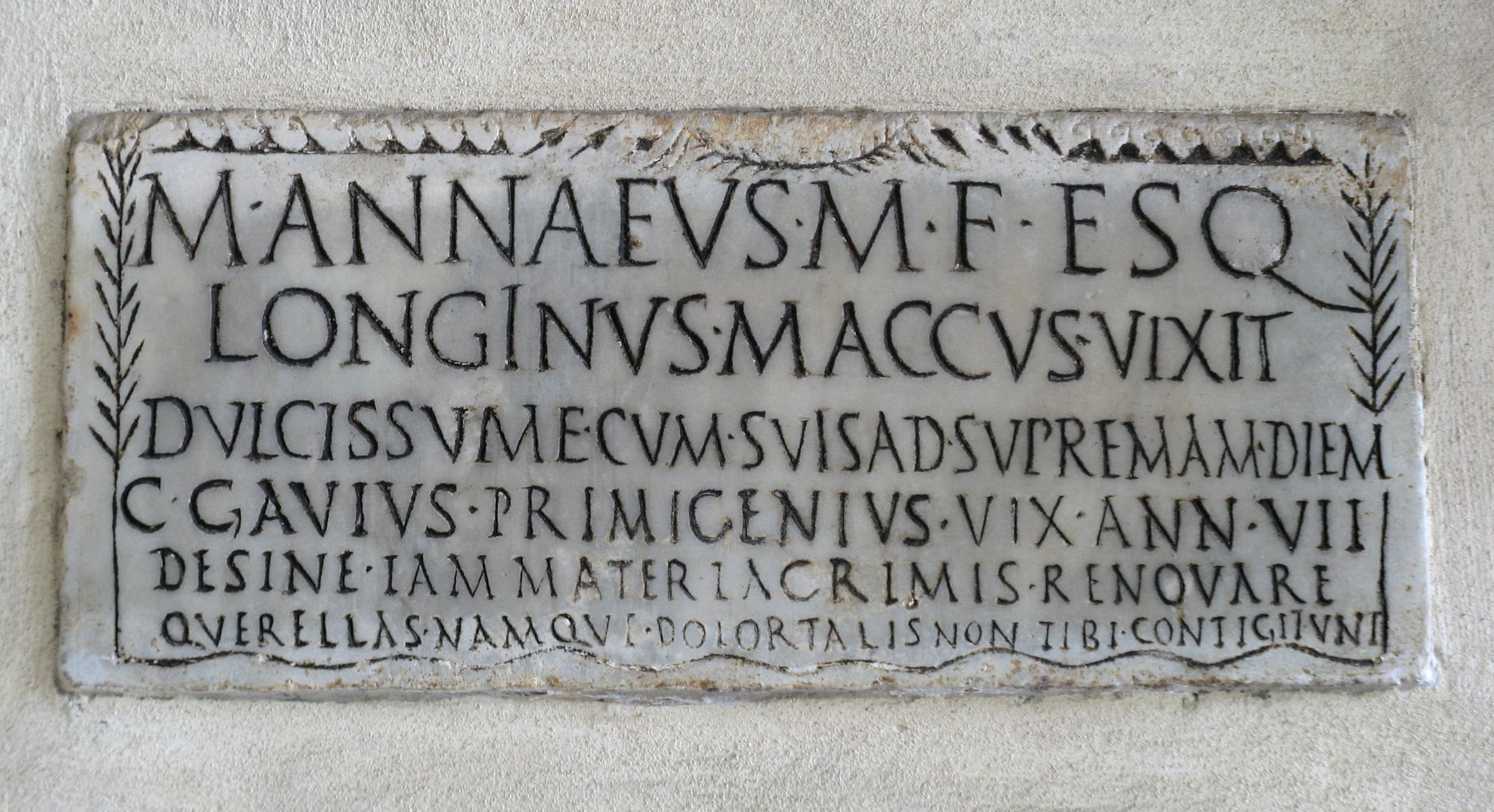 Roman marble funerary tablet with a laurel-leaf frame and a Latin inscription for M. Annaeus Longinus (CIL VI 10105), mounted in the portico of Santa Maria in Trastevere, Rome.