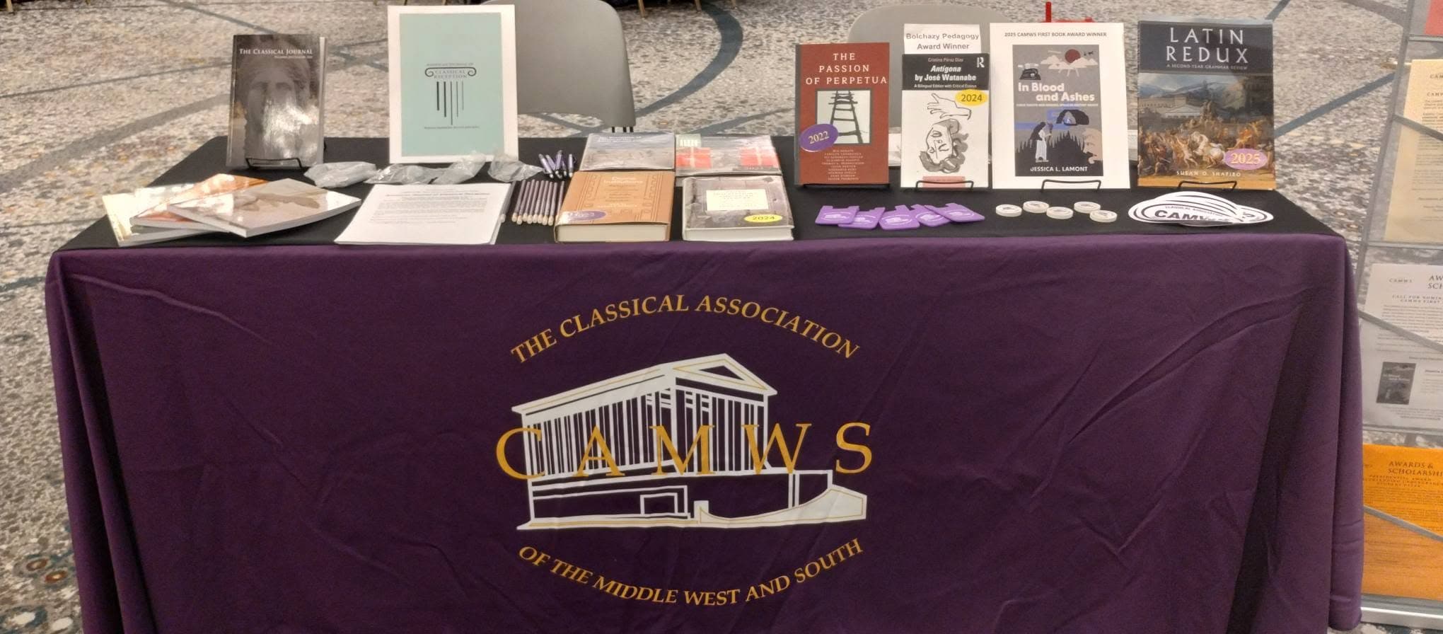 Copies of the Classical Journal and members' books on the purple CAMWS table cloth