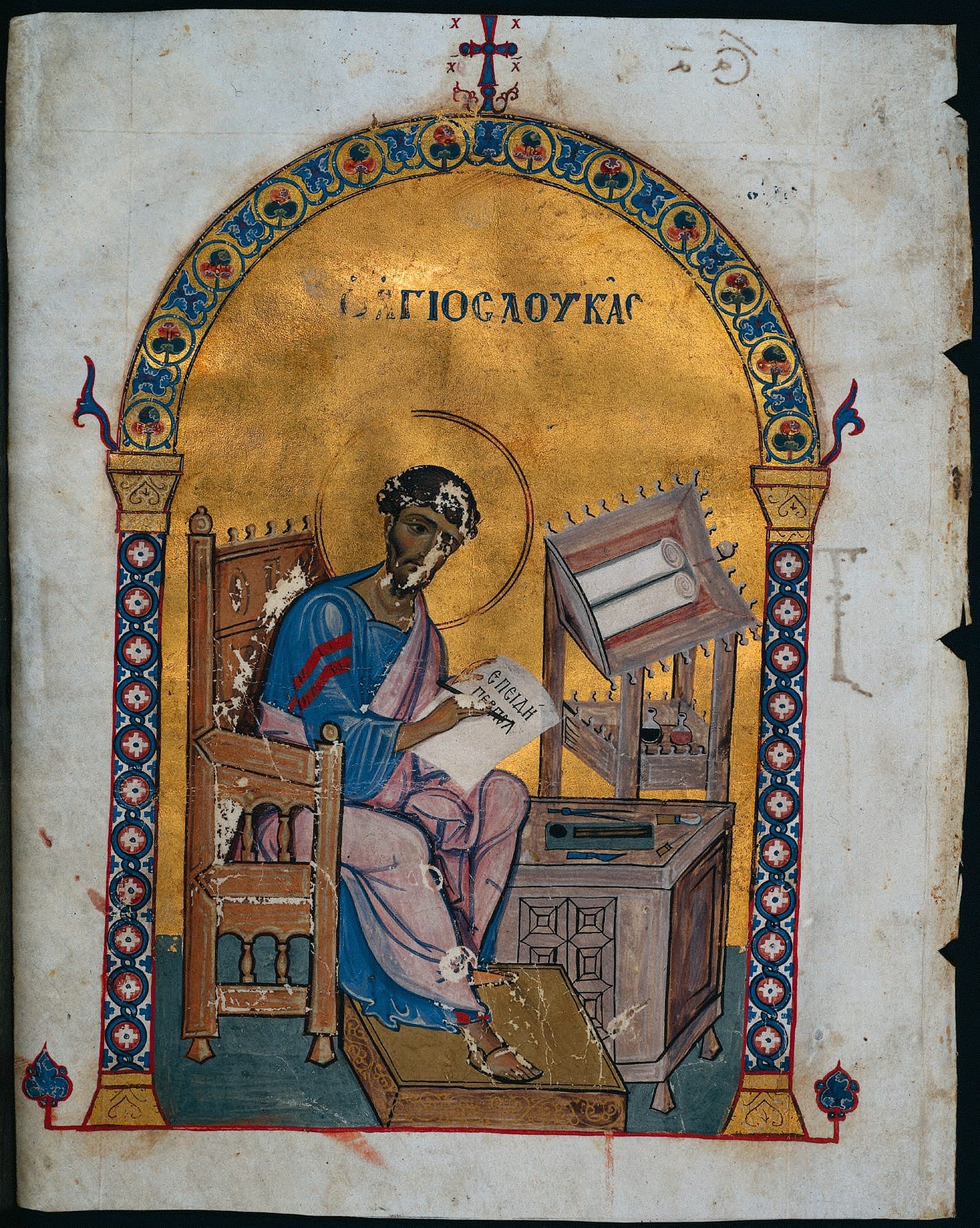 Byzantine manuscript leaf showing St. Luke writing on a scroll at a desk under a jeweled gold arch labeled in Greek.