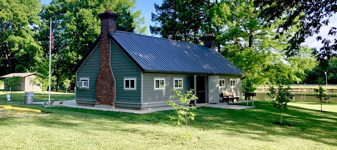 A pavilion rental area near Carlyle Lake, with green lawn and shade trees.