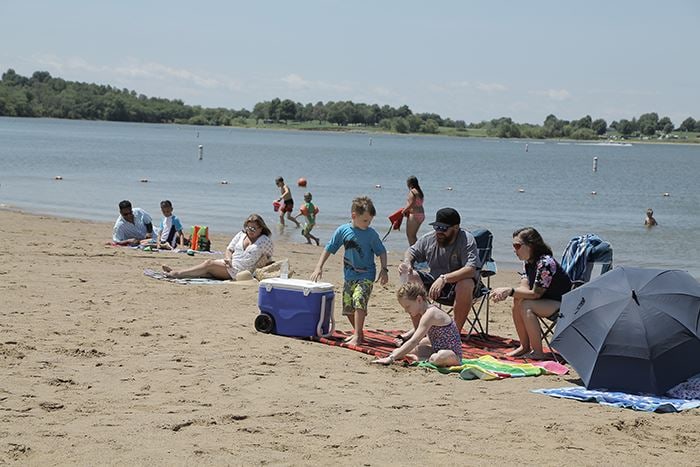 Families on the sand at a Smithville Lake swim beach.