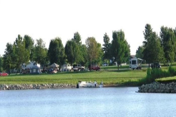Campers along the shoreline of a Smithville Lake campground, with a boat on the water in front.
