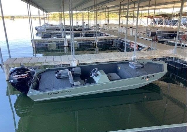 A fishing boat tied up at the covered marina slips.