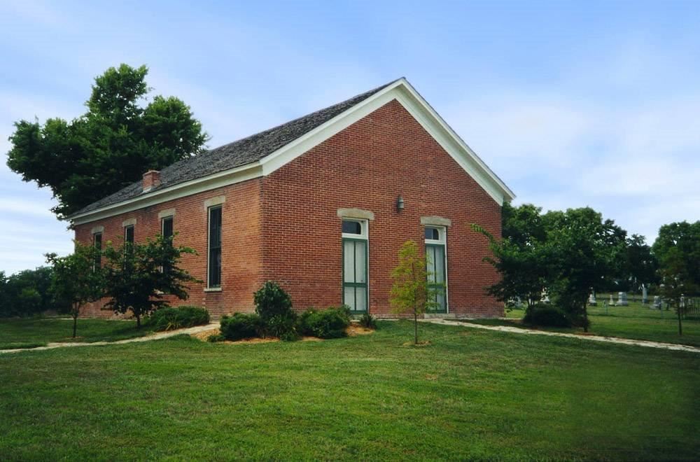 The red-brick Mt. Gilead Church, its gable end with two tall green-trimmed windows facing the lawn.