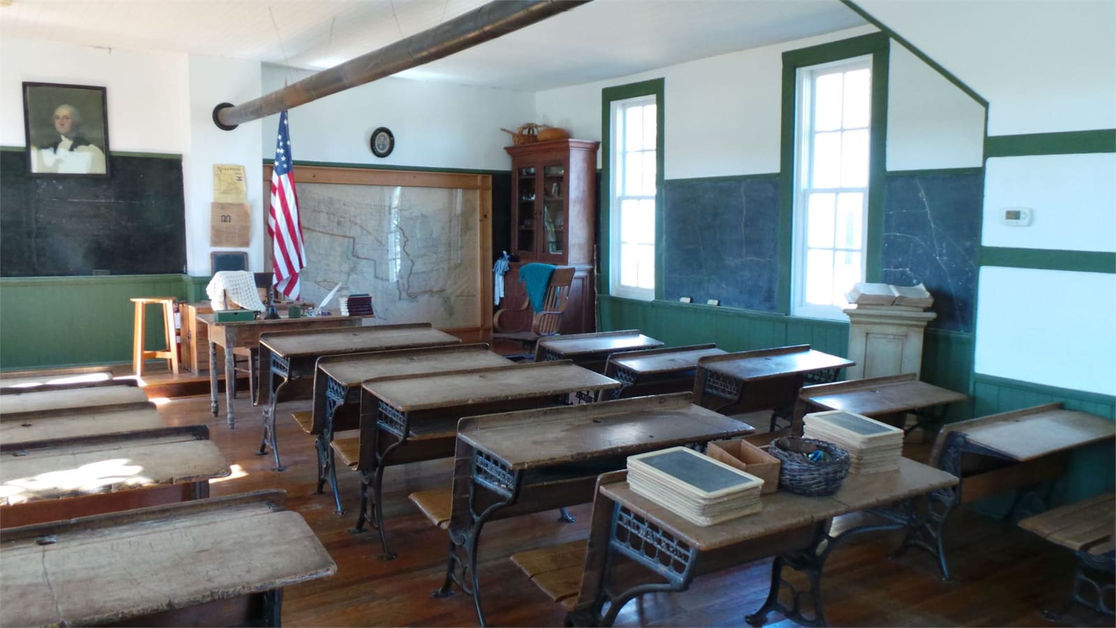 Rows of wooden desks with slates inside the Mt. Gilead School.