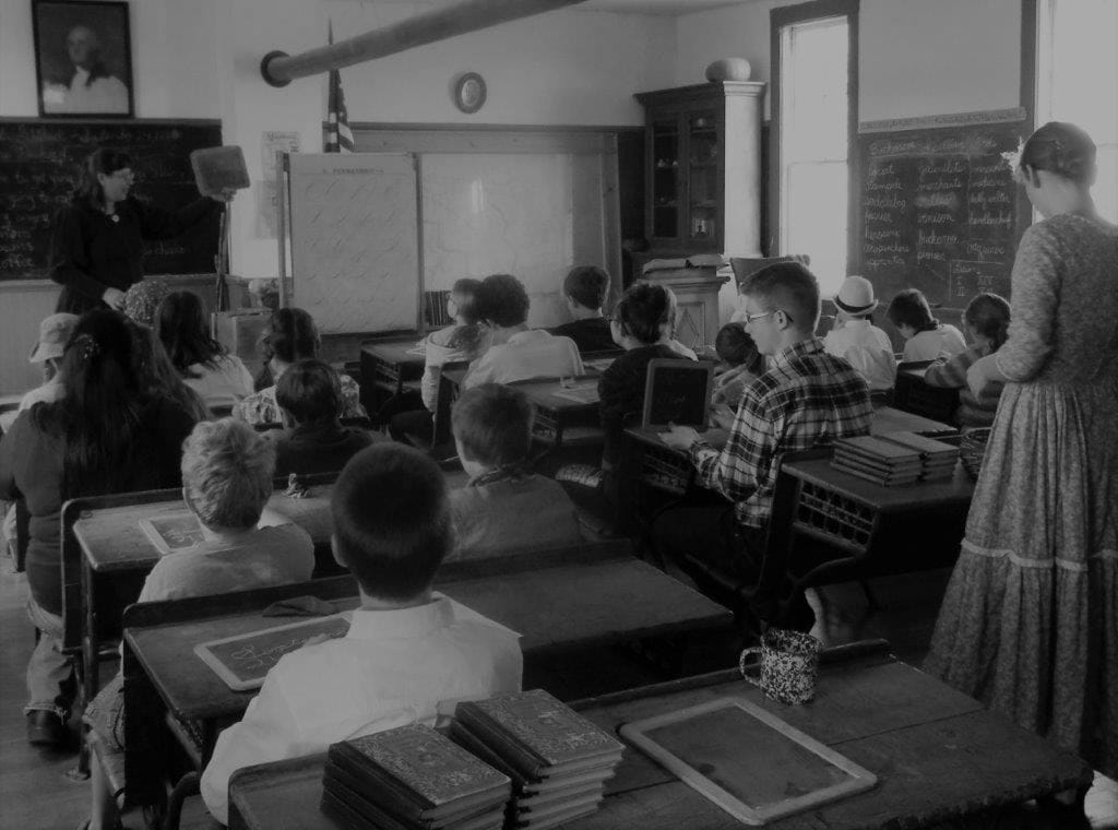 Students at wooden desks during a living-history lesson.