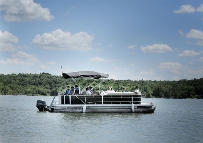 A rental pontoon boat with passengers on the lake.