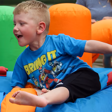 A boy playing on an inflatable slide at the Big Backyard Party