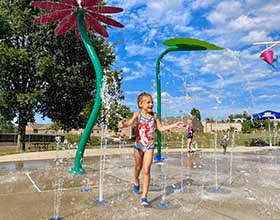 child playing in the sprayground at Activity Center Park