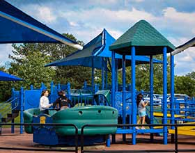 A blue and green playground with three children playing