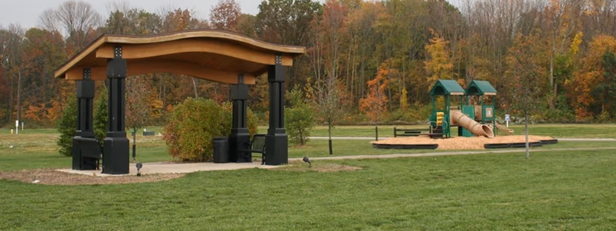 A wave-roofed shelter and playground at Divided Ridge Park in fall