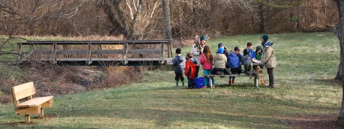 A naturalist and children at a picnic table at Forest Walk Park