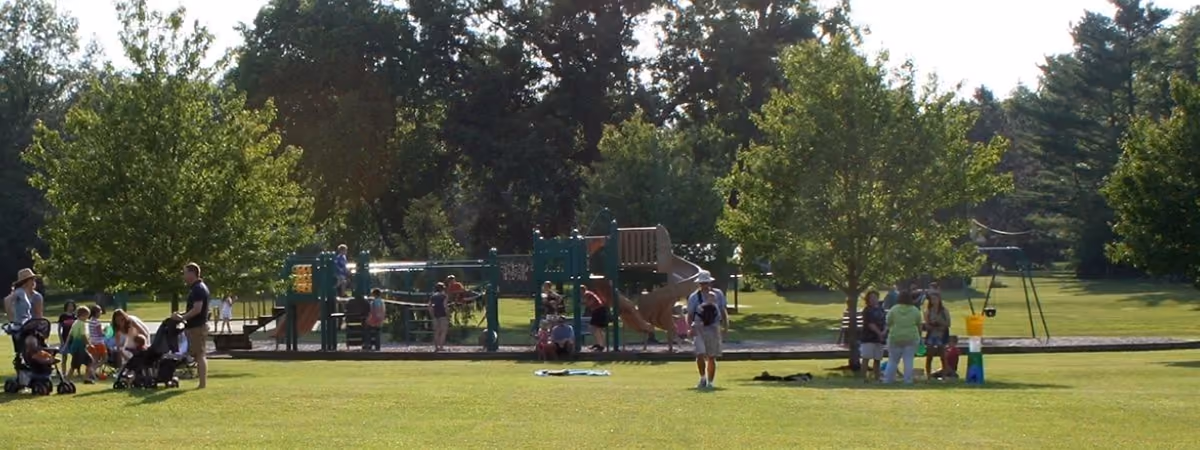 Families on the lawn and playground at Green Park