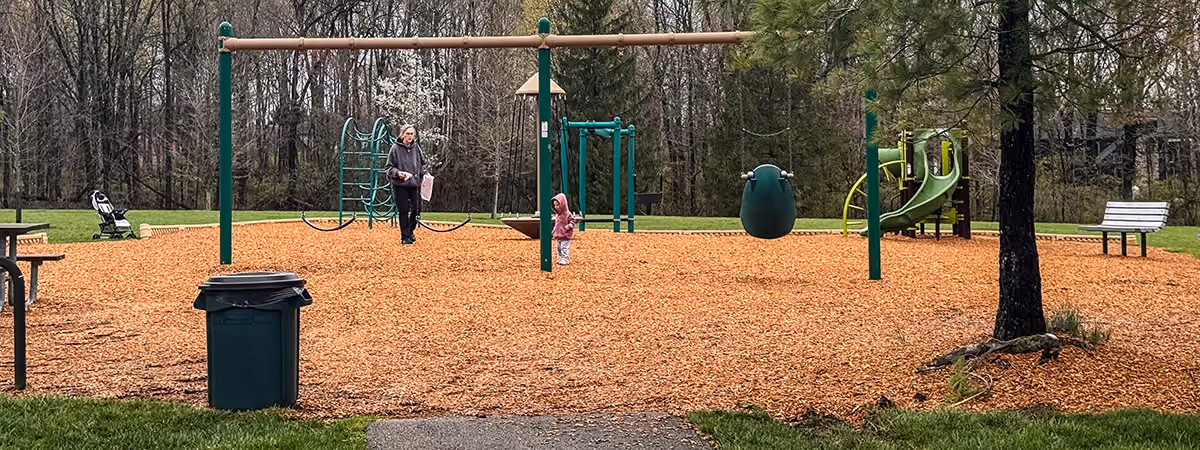 An adult and a toddler at a park playground
