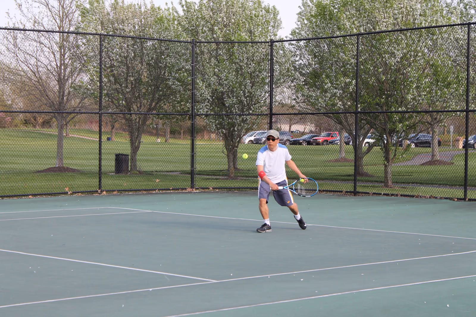 A tennis player returning a ball at Forest Field Park
