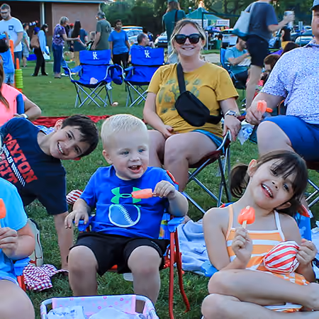 Families in lawn chairs at an outdoor movie night