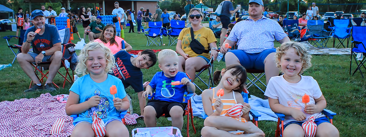 Families in lawn chairs at an outdoor movie night