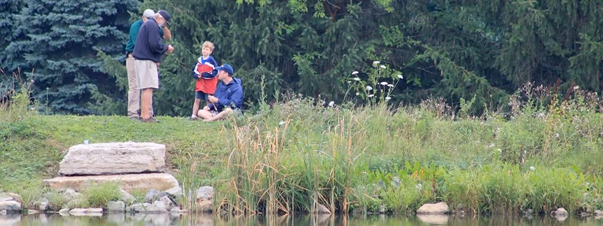 A boy fishing from the bank of the pond at Oak Grove Park