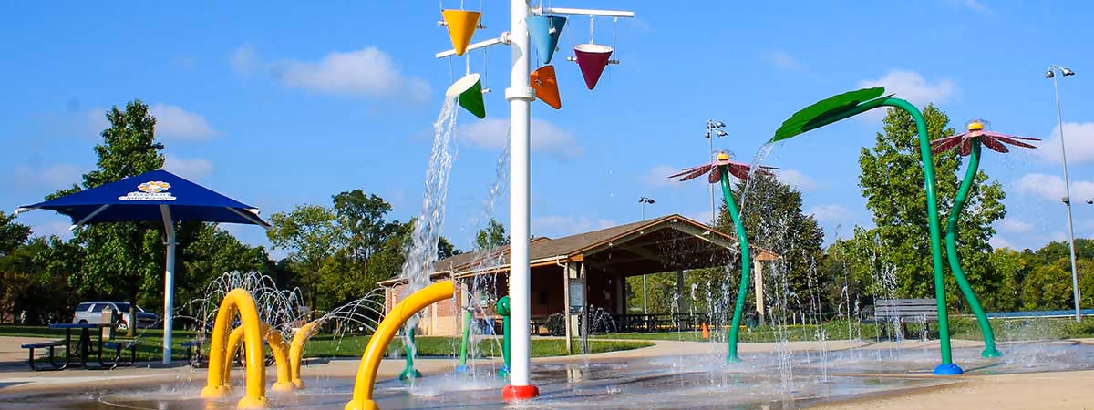 Water arcs over the sprayground at the Activity Center Park