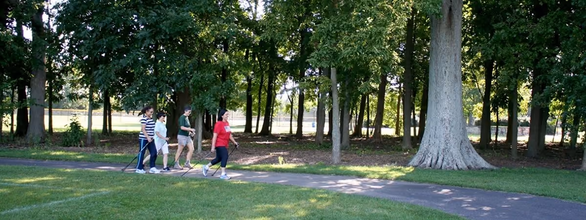 Walkers with Nordic poles on the paved path at Schoolhouse Park