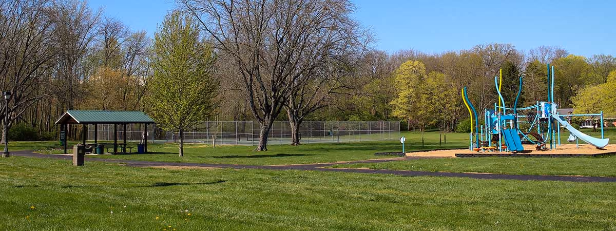 Small shelter, drinking fountain, paved path, tennis courts and playground at Centerville-Washington Park District's Village South Park