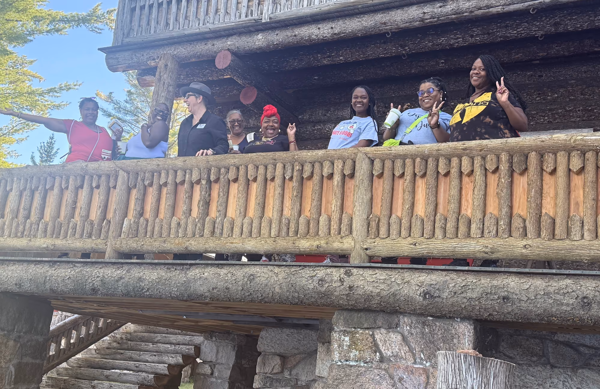 Retreat participants waving from the lodge balcony