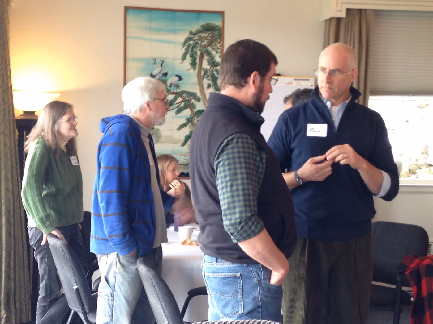 Attendees talking in a standing circle between sessions at an ADI gathering