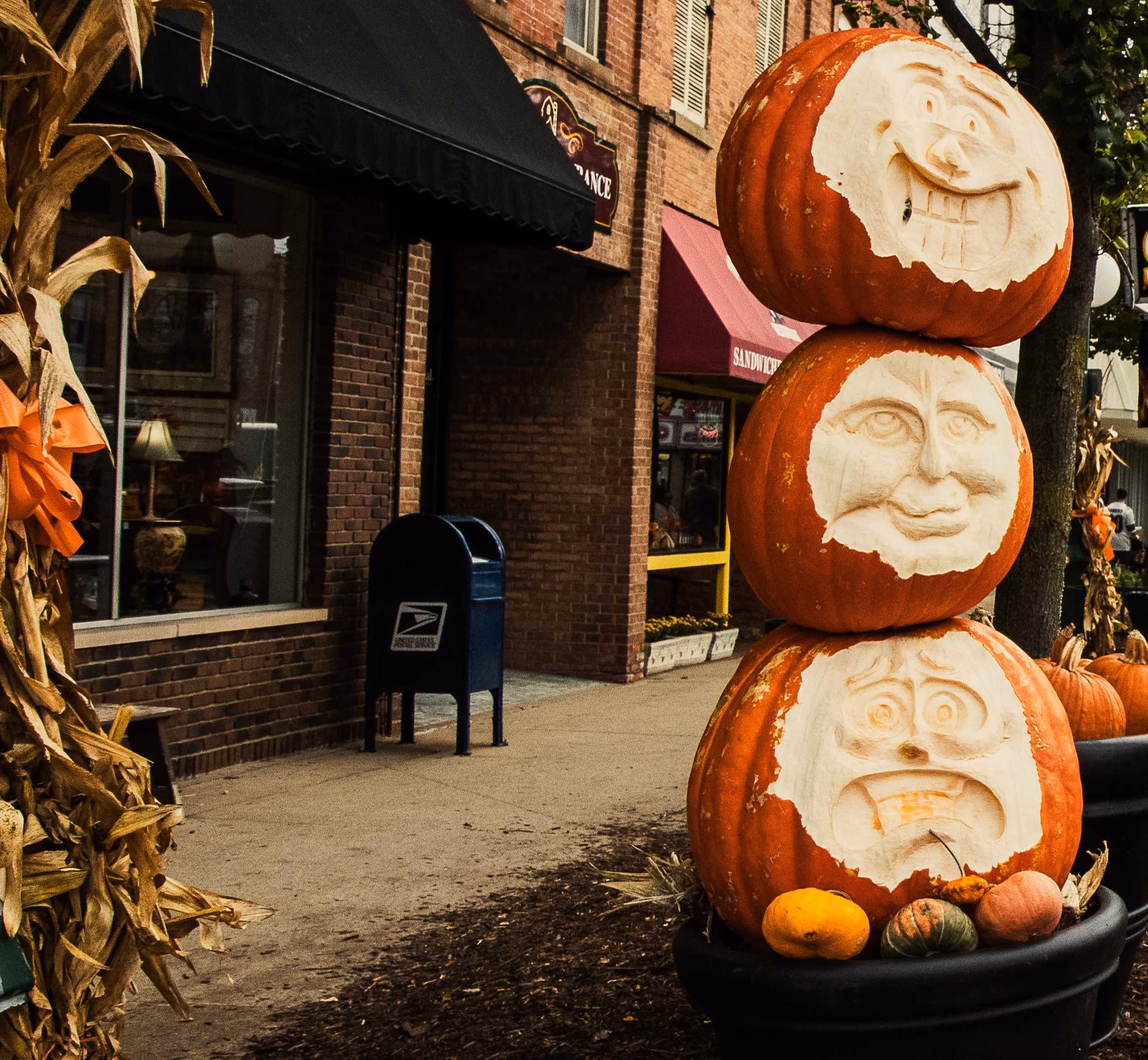 Carved pumpkins beside a brick storefront on Chicago Boulevard during Appleumpkin