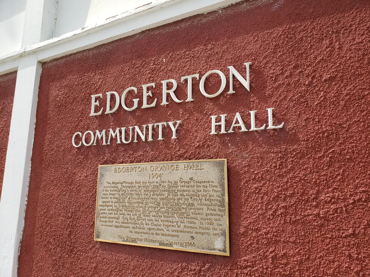 The words Edgerton Community Hall and a plaque on the building's red wall.