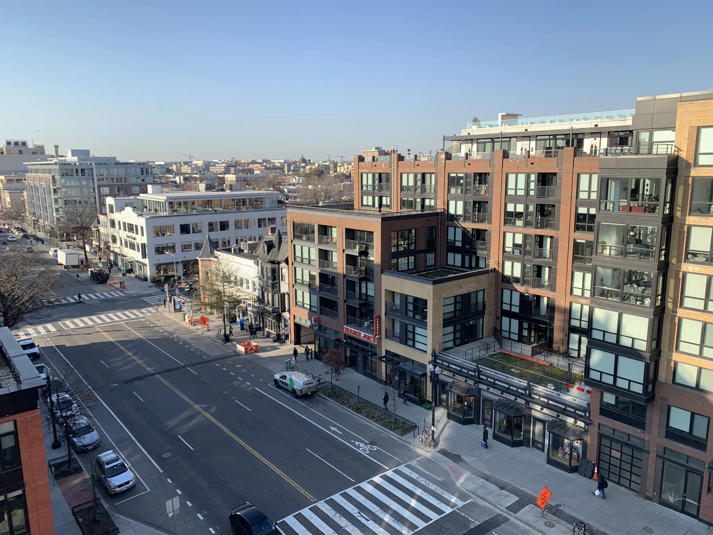 Apartment buildings, storefronts and a crosswalk along 14th Street NW in Washington, DC.