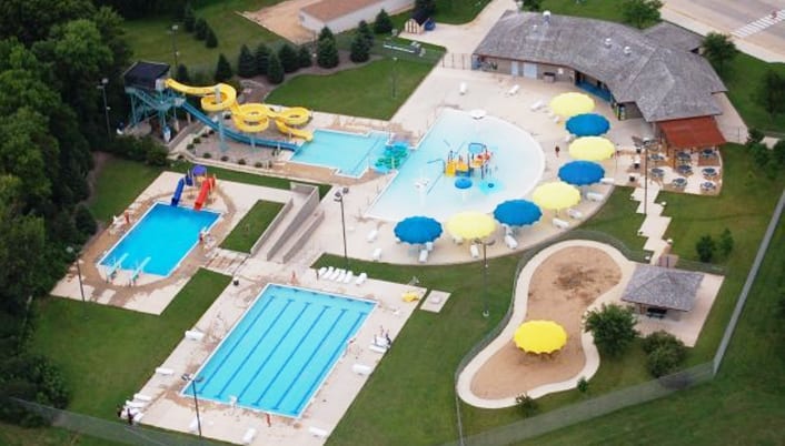 The Fairmont Aquatic Park from the air: waterslides, lap and leisure pools, and shaded umbrella decks