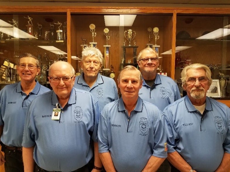 Six Citizens On Patrol volunteers in their program shirts at the police department