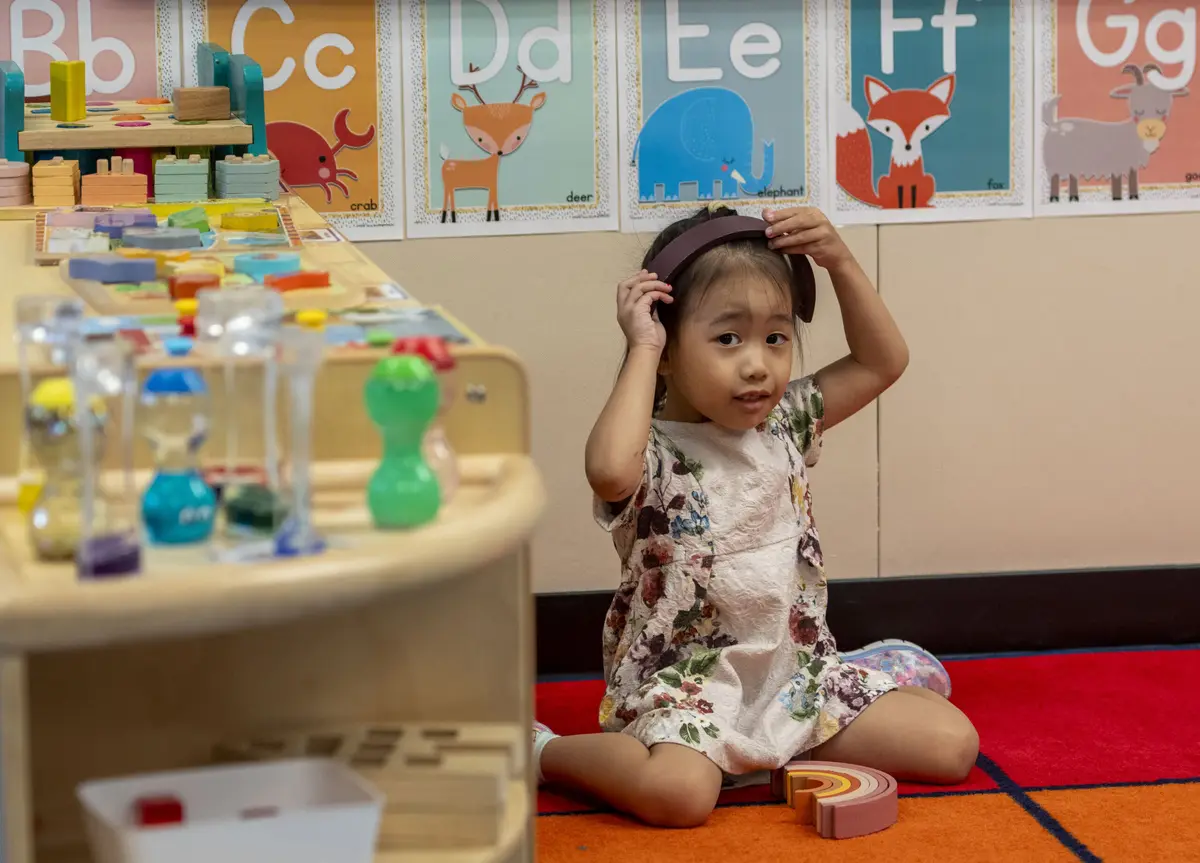 A young child exploring an early-learning classroom