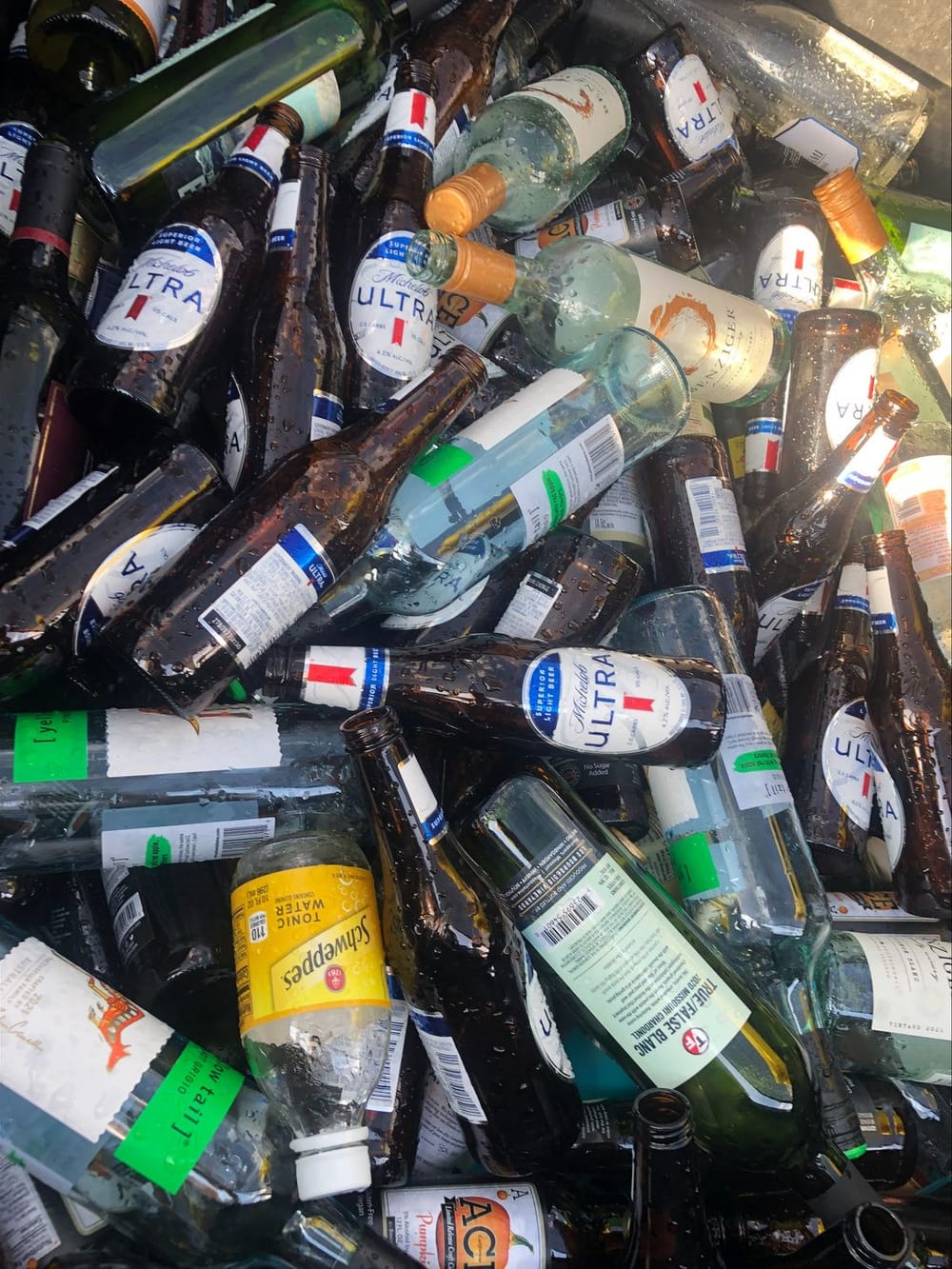 A trailer bed heaped with glass bottles and jars collected for recycling.