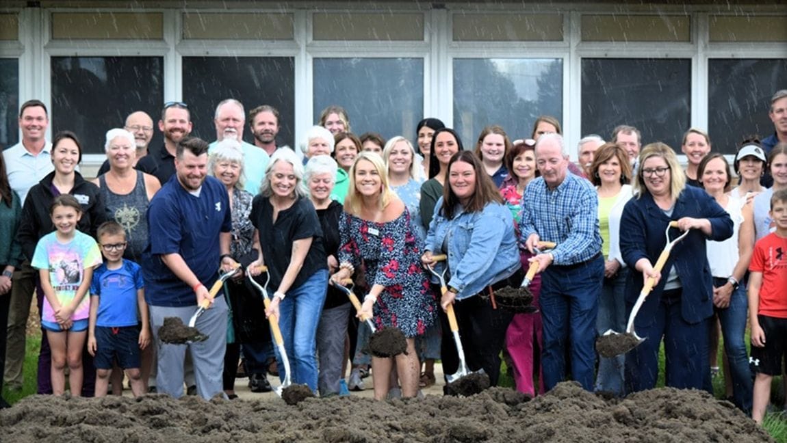 A crowd of community members, children, and local officials with gold shovels at the Carroll County Area YMCA groundbreaking.