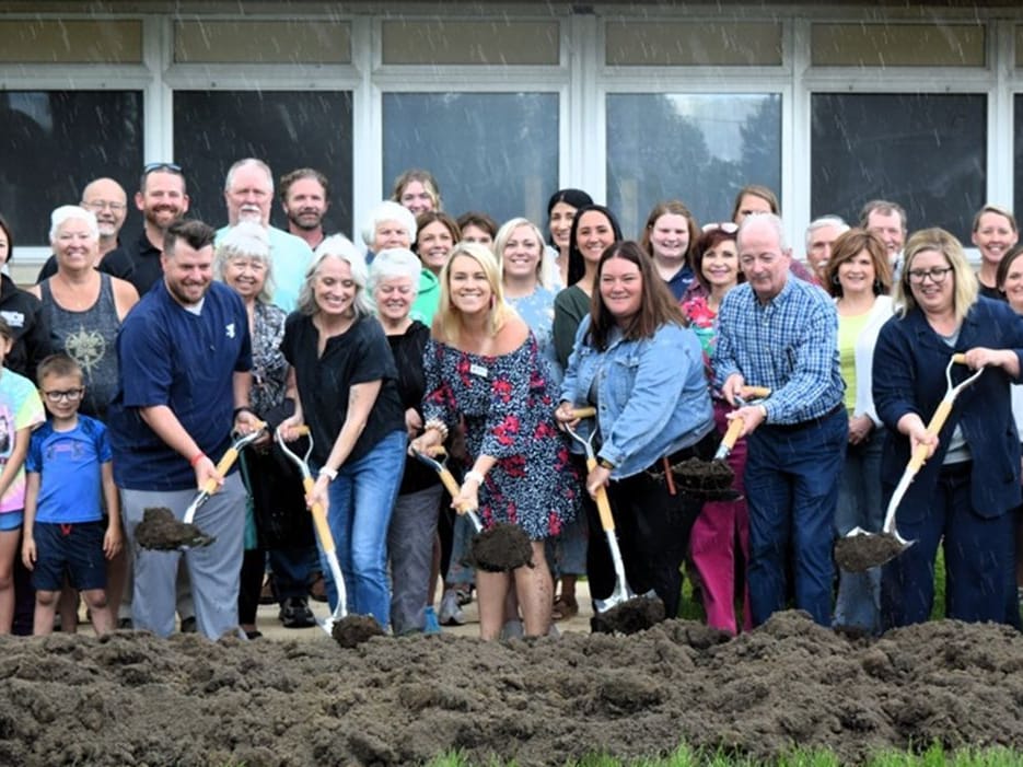 A crowd of community members, children, and local officials with gold shovels at the Carroll County Area YMCA groundbreaking.