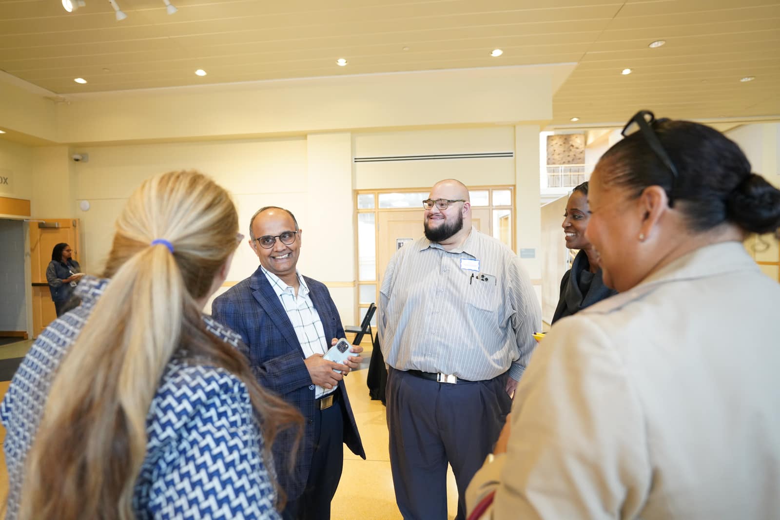 Partners from American Diversity Group and the Prevention of Blindness Society in conversation in the gallery hall