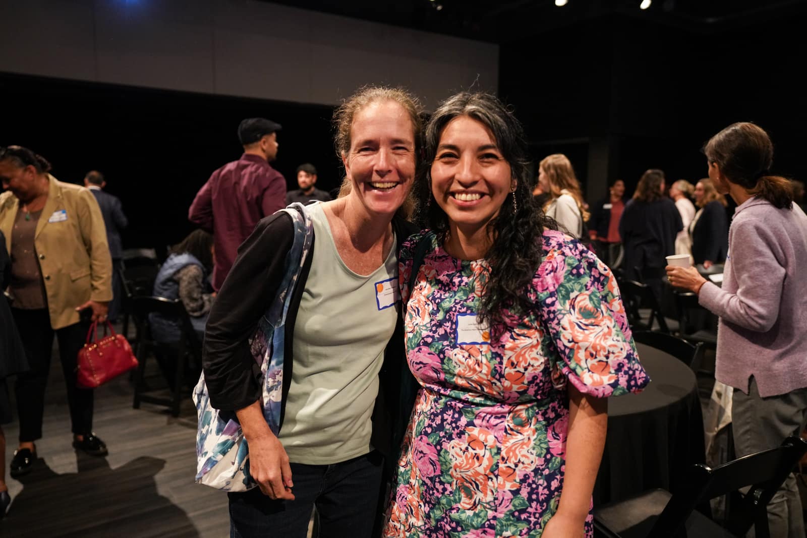 Two women laughing together at HIF's 50th Anniversary breakfast, with Community FarmShare