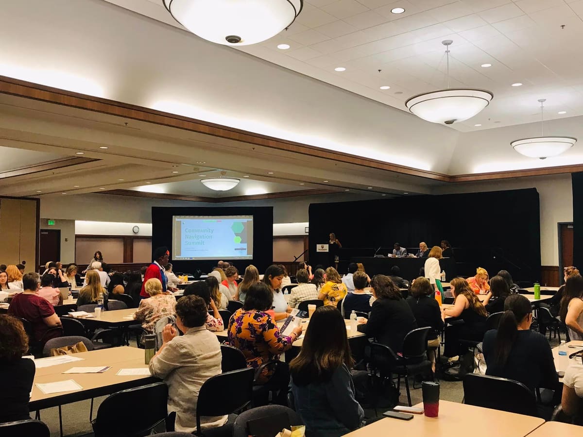 A full room of community partners at tables during the Community Navigation Summit