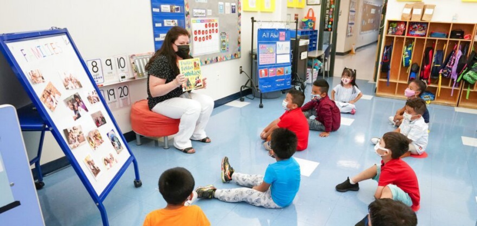 A child care provider reading a picture book to a group of young children