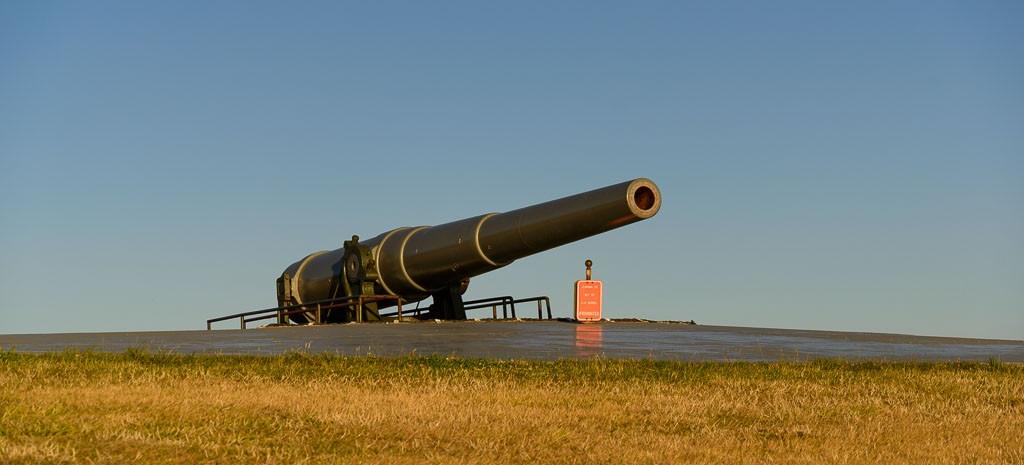 The ten-inch gun at Fort Casey pointing over Admiralty Inlet in low golden light
