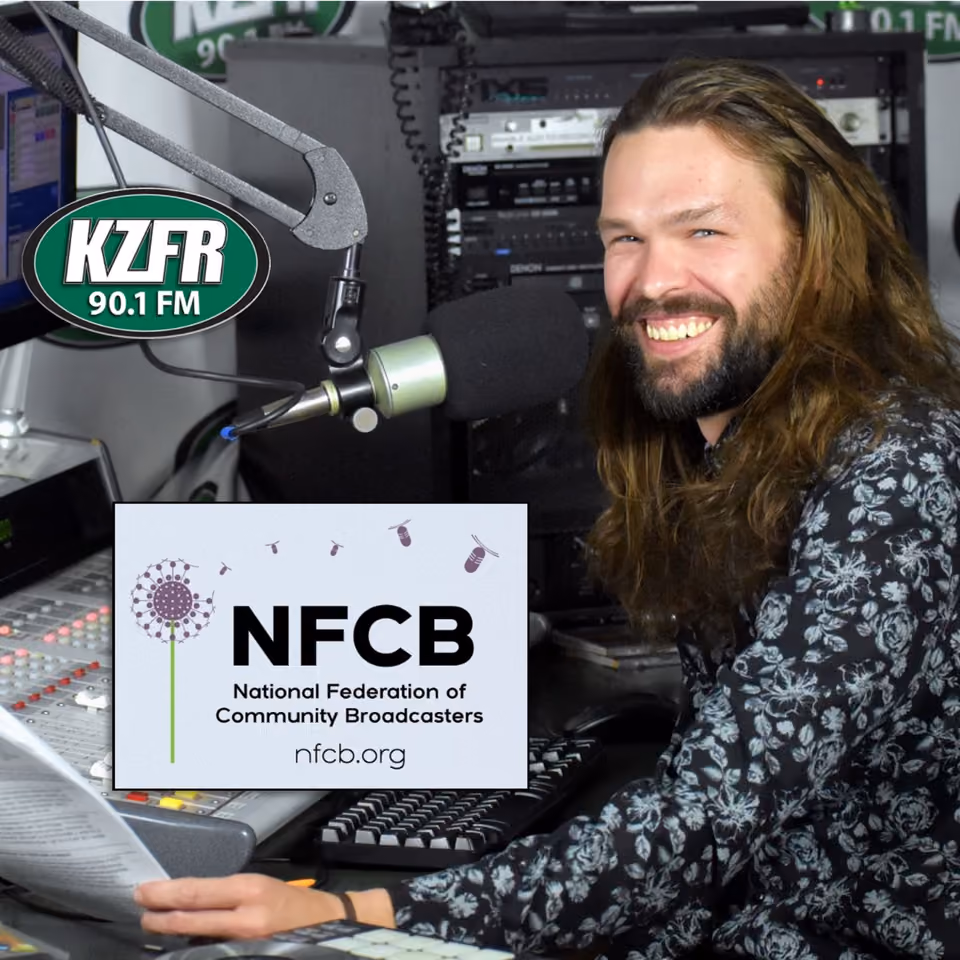 Smiling long-haired man at a KZFR 90.1 FM studio microphone, with an NFCB National Federation of Community Broadcasters logo overlaid