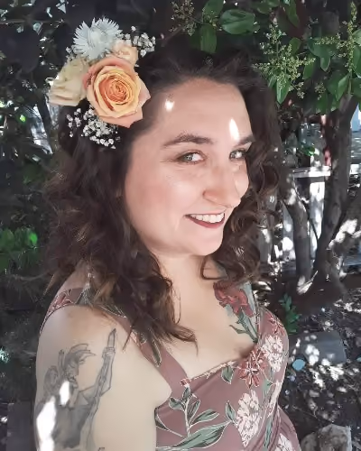 Smiling woman with wavy dark hair, a pe