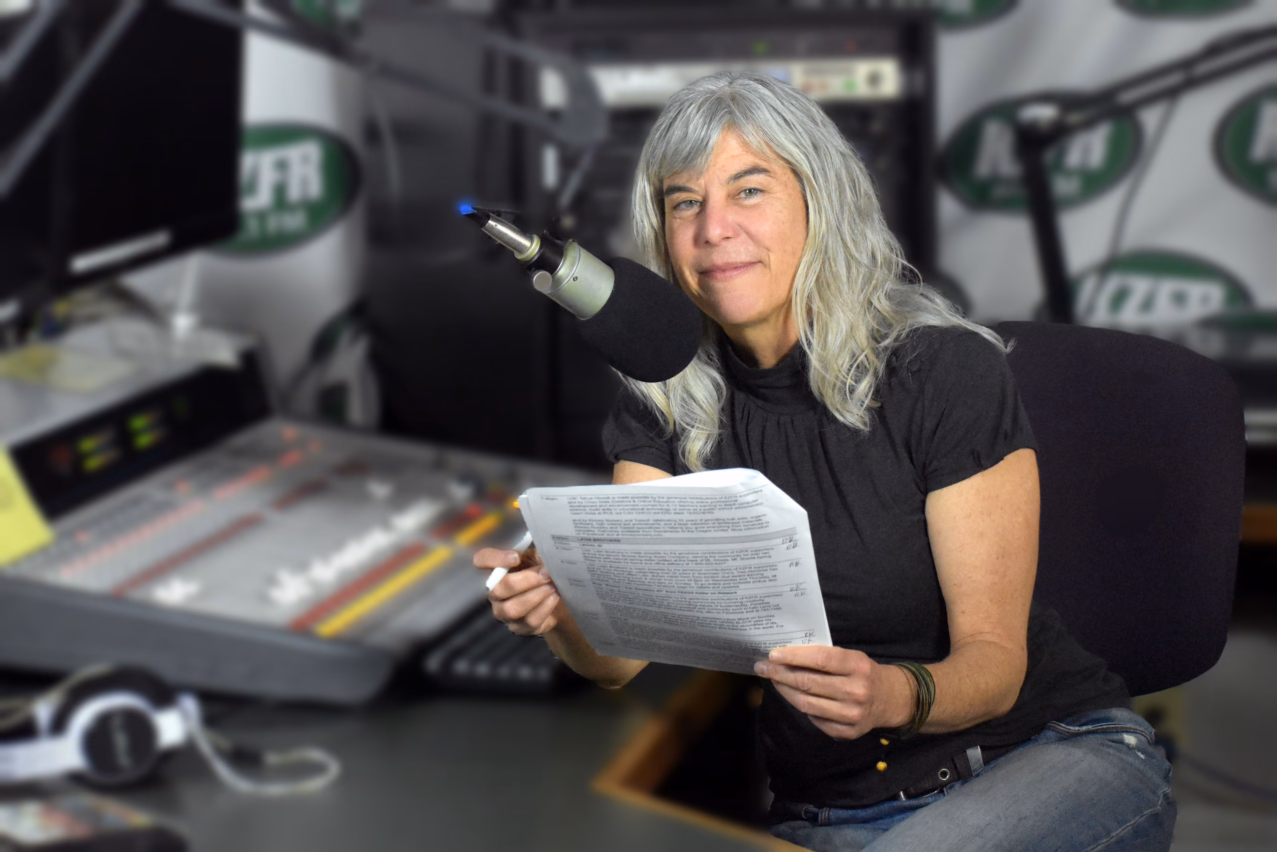 Sue at the KZFR studio board, script in hand beside the microphone.