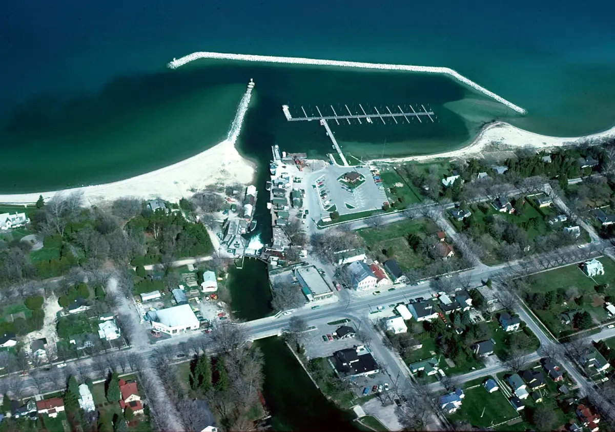 Aerial view of Leland, with the river joining Lake Leelanau to Lake Michigan and the harbor breakwaters extending west