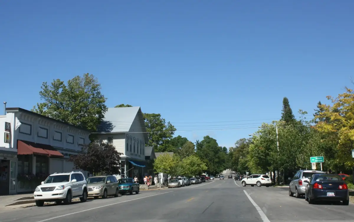 Downtown Leland along M-22, with storefronts and people on the sidewalk